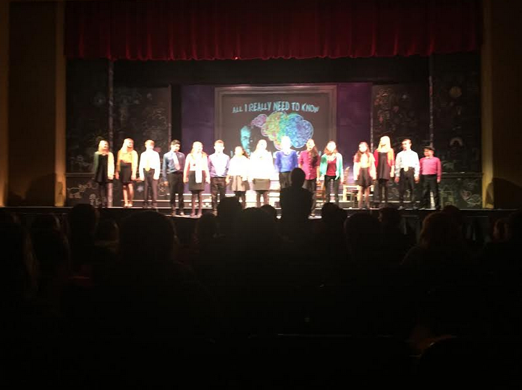 The cast of the freshmen play stand during applause. 