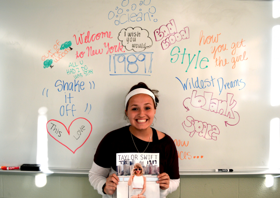 Brianna Ary, senior, stands under the song titles off of 1989. 