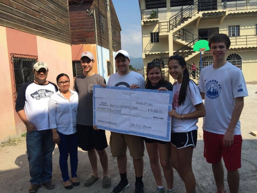Junior Grant Lebedz presents a check for $15,000 to a school in Honduras. Grant, who is a member of Campaign for Classrooms club, worked with other club members to raise money for the Honduras school. 