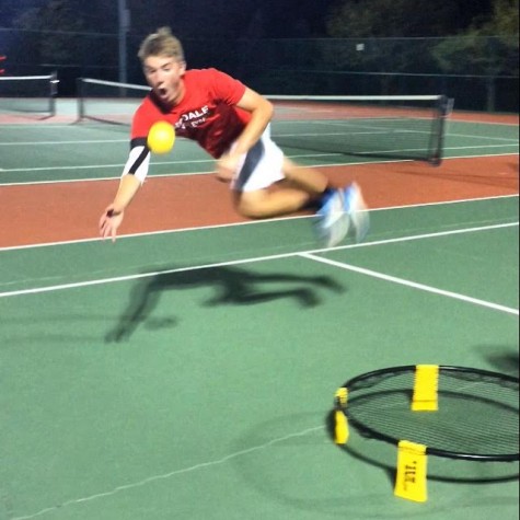 Ellis Kritzer dives to set up his teammate during a game of Spikeball on the school's tennis courts