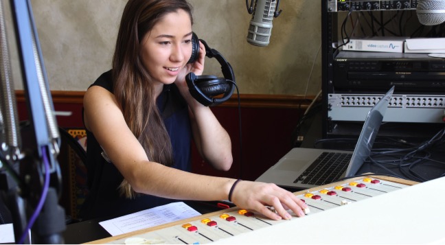 During her radio show on Nov. 7, Bella Tamas uses the audio box in Hinsdale Central’s radio room to change the volume and sound distribution of the music.  Tamas was playing her favorite Bachata artist, Romeo Santos, on air at the time.