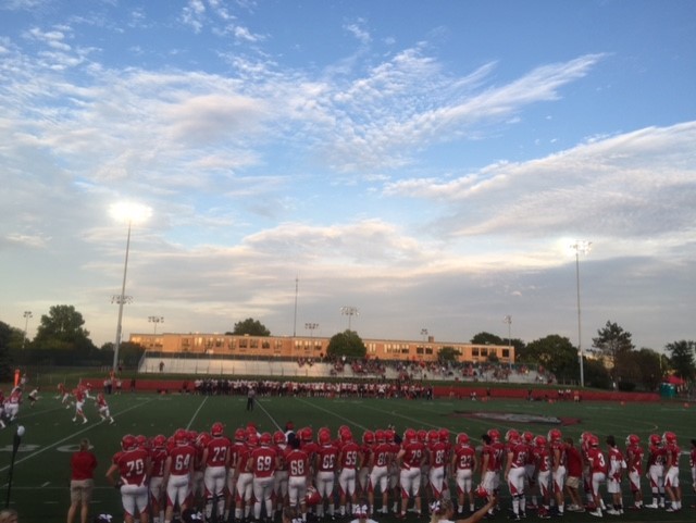 The varsity football team watches their teammates and prepares to sub in at the first game of the season on Aug. 26. 
