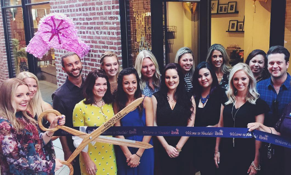 Ashley Carlevato, salon owner, cuts the ribbon during the salons launch party on Sept. 15. 