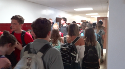 Students must squeeze through huge crowds to get to class due to overcrowding. 