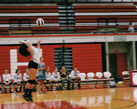 Kya Collier, sophomore, serves the volleyball against Waubonsie Valley High School on Sept. 7. 