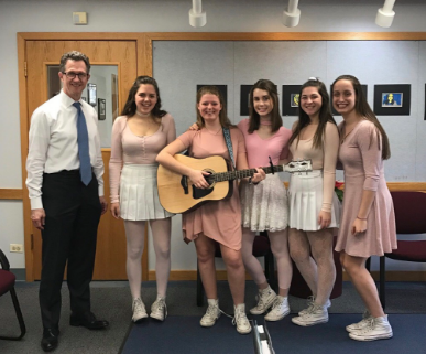 Superintendent, Dr. Bruce Law, enjoys the harmonies of the Singing Valentine group that consisted of Emily Goggin, Elisa Fridholm, Jordan Cibinski, Emily Condon, and Hannah Fuechtman, all sophomores. 