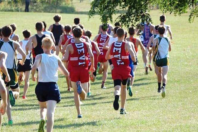 Boys varsity cross-country charges through the grass at the Palatine Invite on Saturday, Sept. 23.