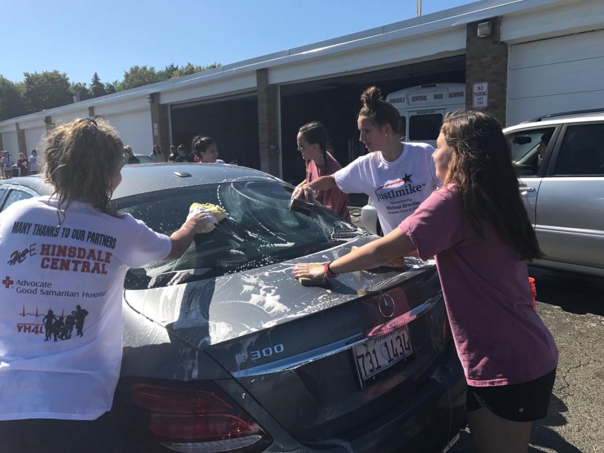 During the fundraiser, the girls swim and dive team set up an assembly line, complete with washing, rinsing, and drying. At the end of the line, there was a table for donations and bake sale items.