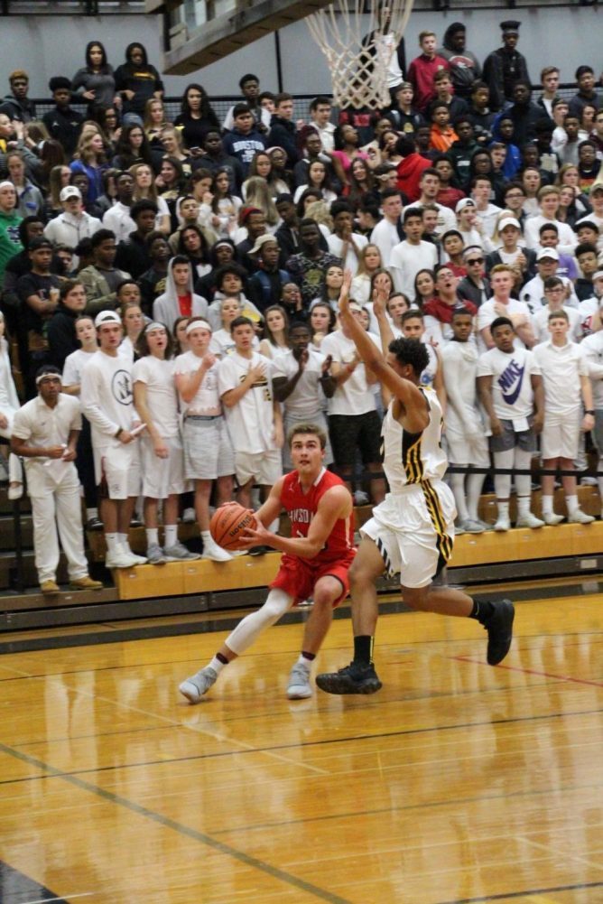 Matt Rush, junior, stares down the hoop before shooting over a Hinsdale South defender.
