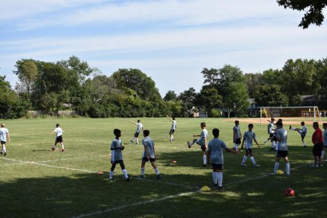 The boys soccer teams start out their practices with a dynamic warm-up.