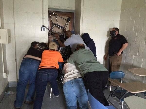 Teachers barricade doors as a part of ALICE training.