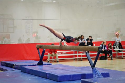 Annette Sommers, sophomore, performs her beam routine on Friday, Nov. 22 at the gymnastics meet.