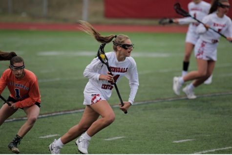 Jenna Collignon is seen sprinting across the field cradling the ball in her lacrosse stick in a game against Saint Charles during the 2019 season.