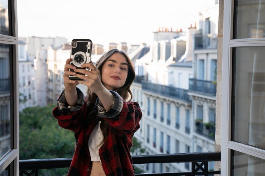Emily takes a selfie in her new apartment in Paris to show off the view to her Instagram followers. 