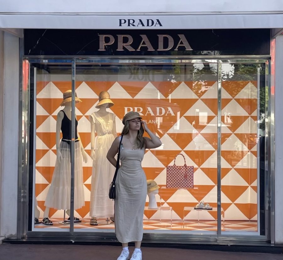 Helena Tragas, junior and self-proclaimed shopaholic, poses in front of a Prada storefront.