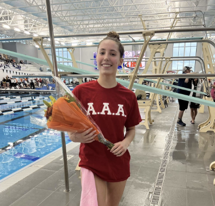 Meghan Martell, sophomore diver, poses with a bouquet after breaking the record for Sophomore Diving 6.