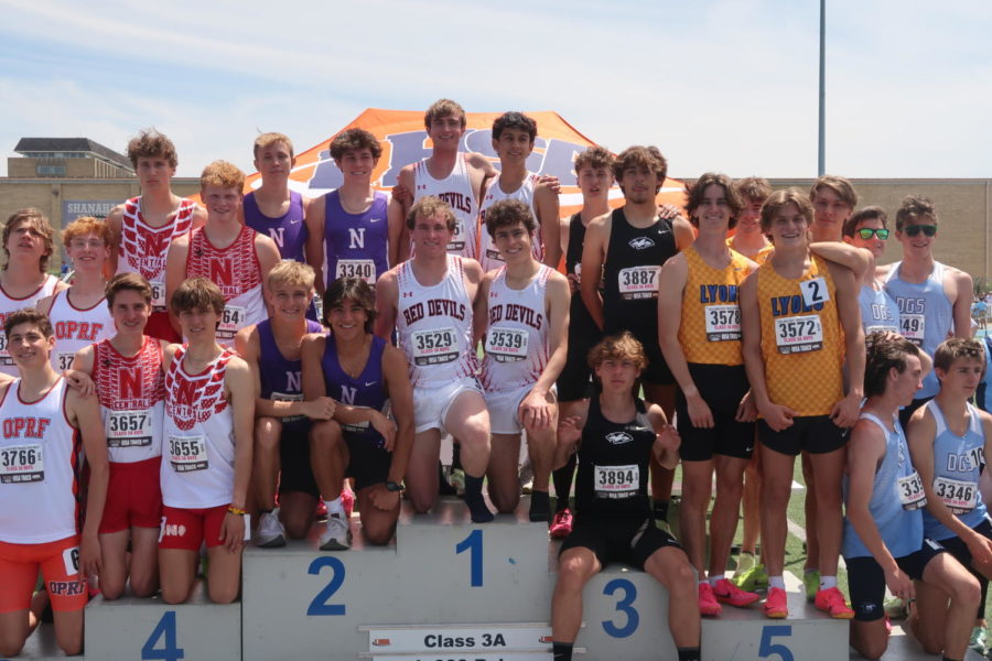 4x800 relay runners on the podium next to fellow competing schools.