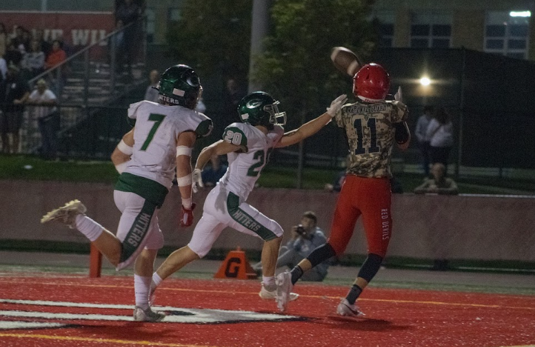 The Devils catch the ball despite efforts for an interception from the Hilltoppers.