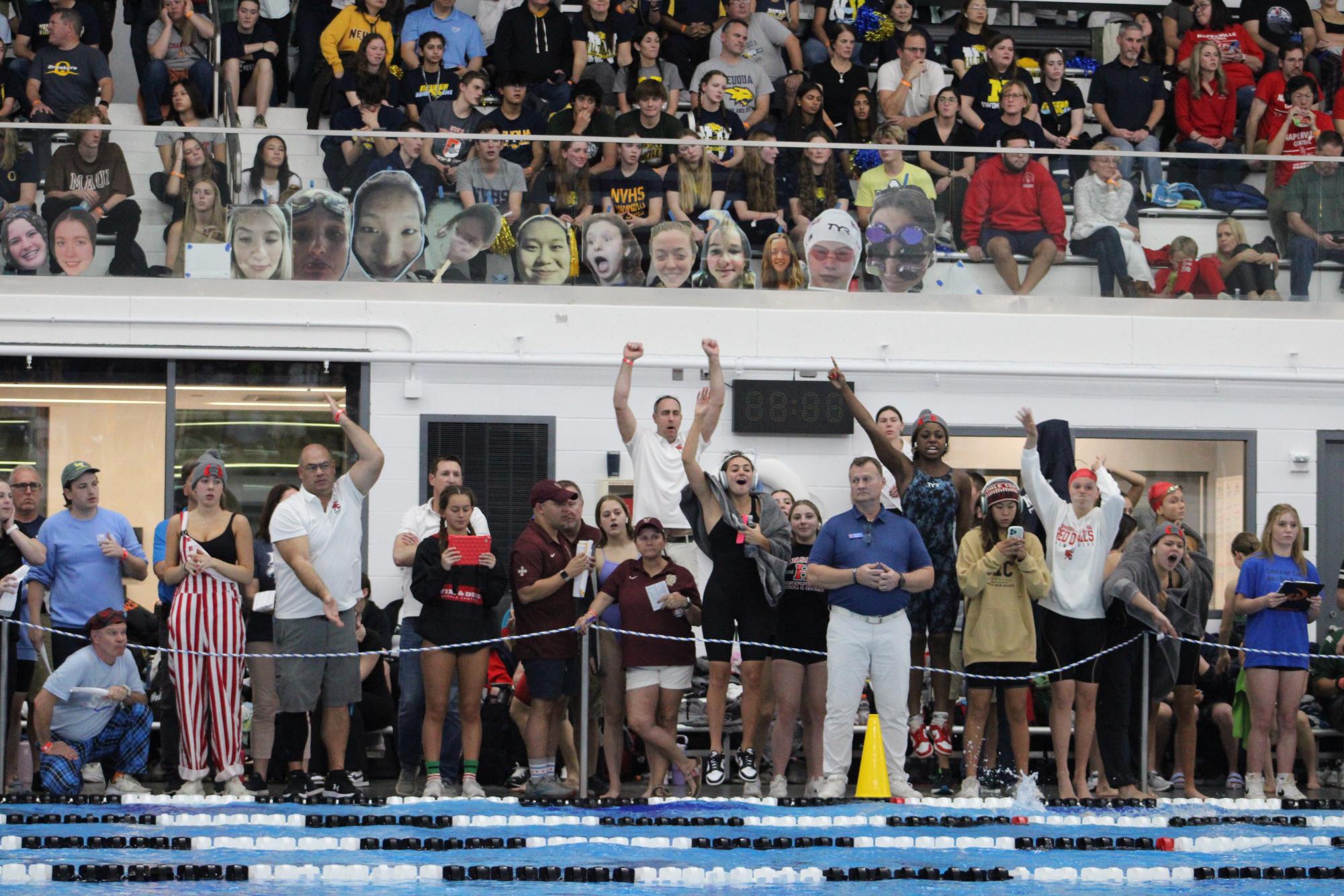 Varsity swimmers cheer on their fellow teammates.
