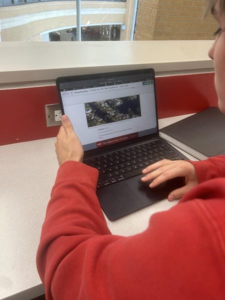 Elias Argyris, junior, reads a news article on Hurricane Milton on his school computer.
