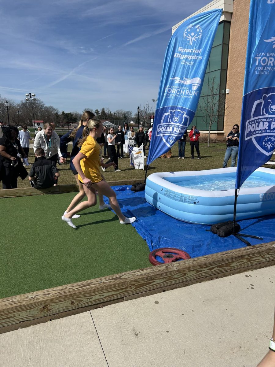 Seniors Sophie Reiff and Mia Sullivan jump into the inflatable pool during the polar plunge on March 20 to raise money for Special Olympics. 