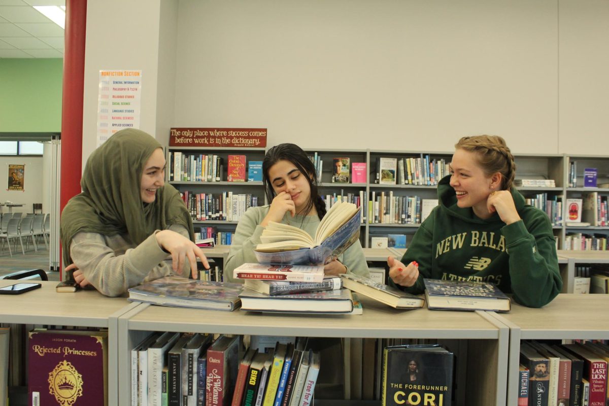 Seniors Iman Halabi, Raya Sulaman and Abby McCarthy all reading books together