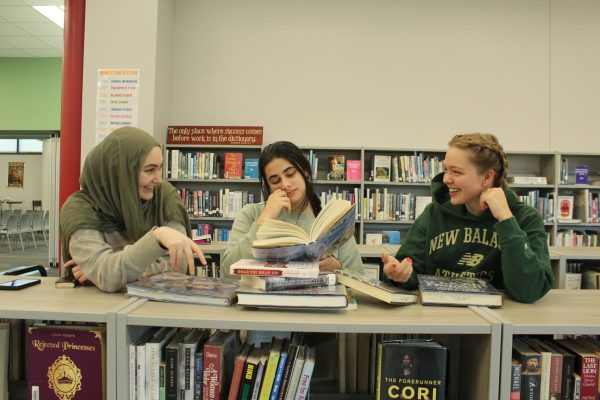 Seniors Iman Halabi, Raya Sulaman and Abby McCarthy all reading books together